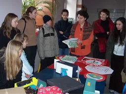 Kinder und Erwachsene stehen um einen Tisch mit Spielmaterial.