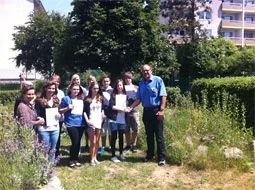 Die Schulsieger halten ihre Praktikumsberichte im Schulgarten in die Kamera.