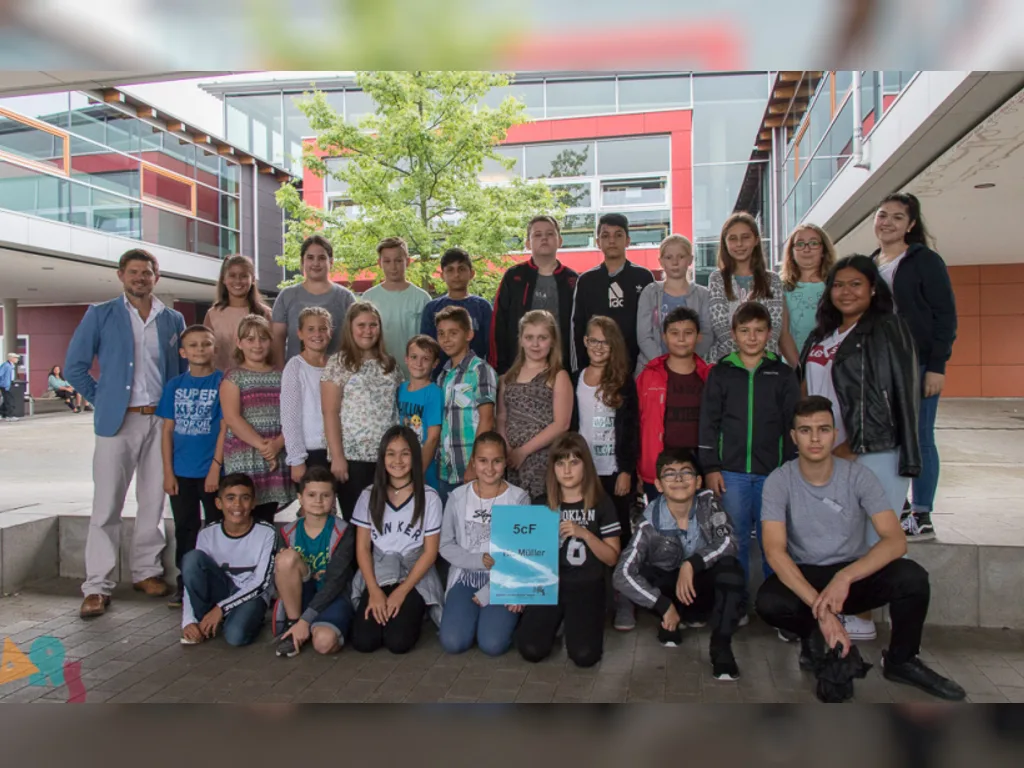 Klassenfoto einer neuen fünften Klasse vor dem Schulgebäude.