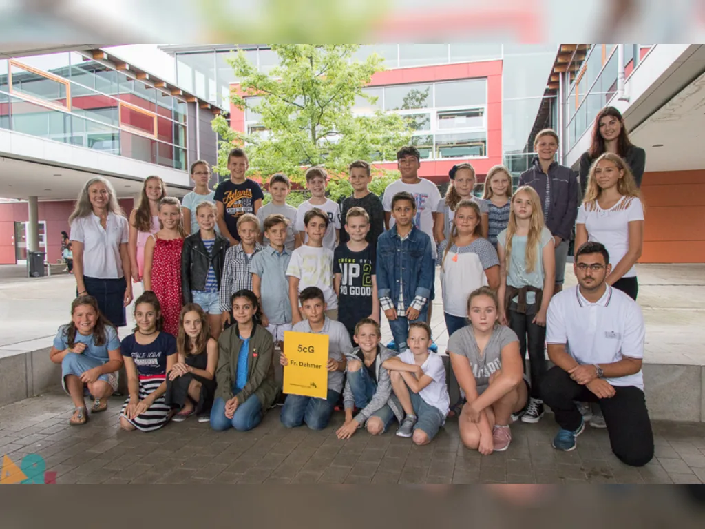 Klassenfoto einer neuen fünften Klasse mit gelbem Klassenschild.
