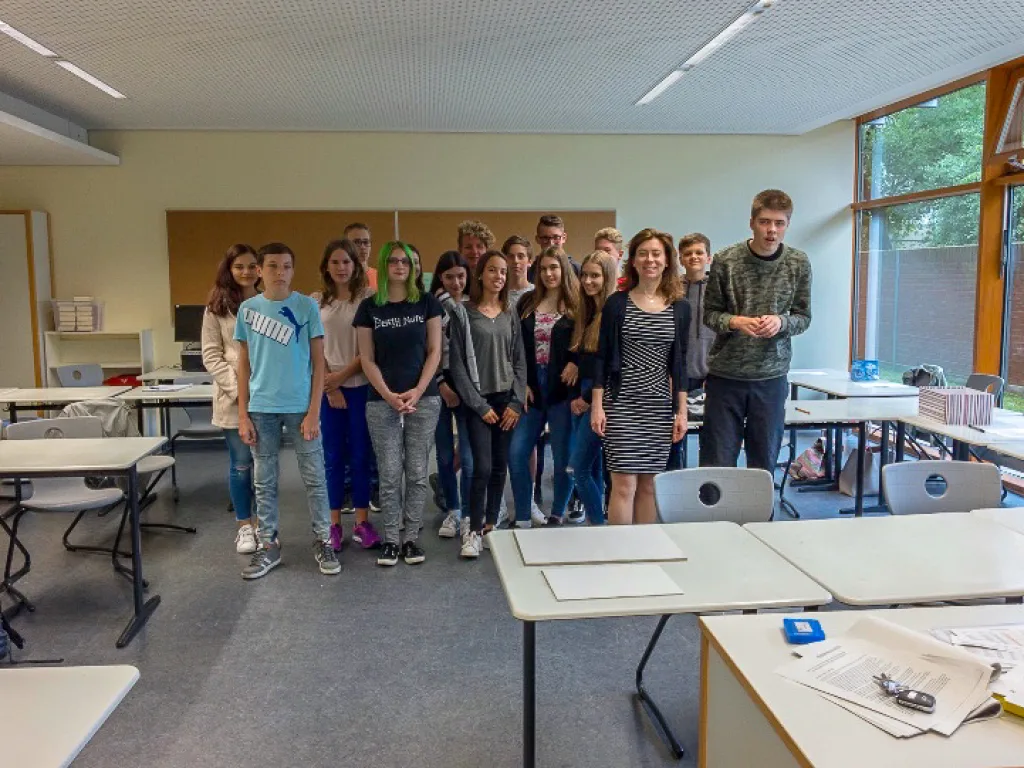 Klassengruppe steht für ein Foto im Klassenraum.