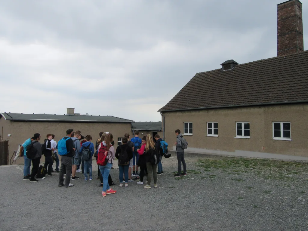 Gruppe steht auf dem Appellplatz vor den Gebäuden der Gedenkstätte.
