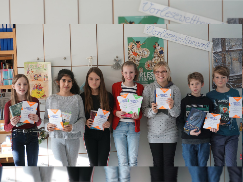 Die Jugendlichen präsentieren stolz ihre Urkunden vom Vorlesewettbewerb.