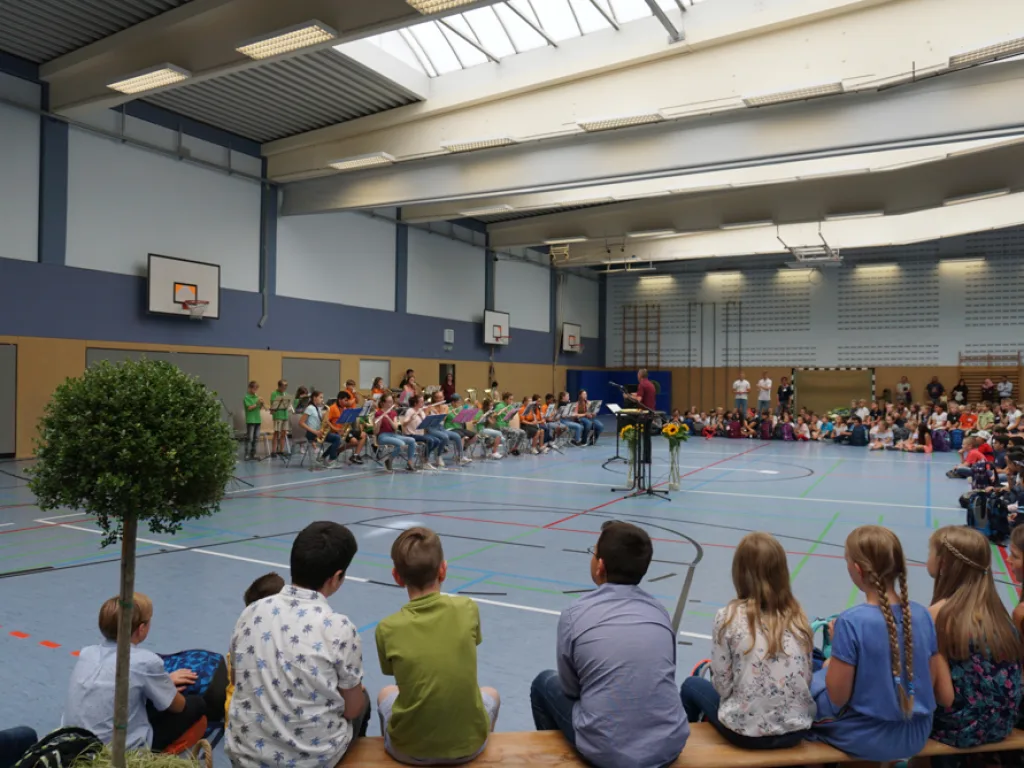 Kinder und Erwachsene verfolgen das Programm in der Halle.