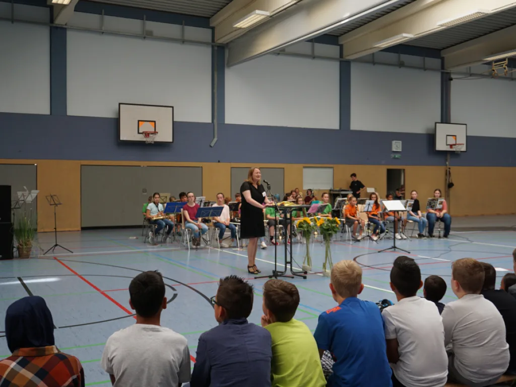Blick über die sitzenden Kinder auf die Hallenmitte.