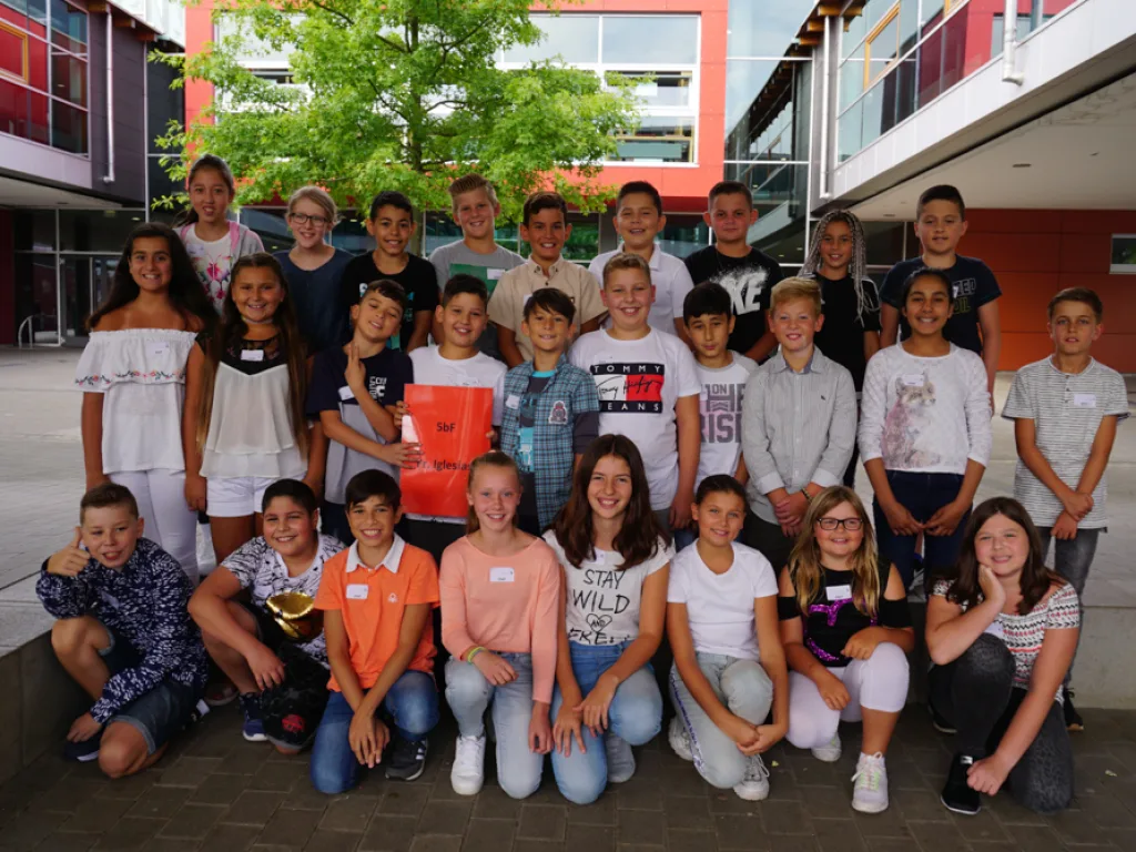 Klassenfoto einer neuen fünften Klasse vor der Fassade.
