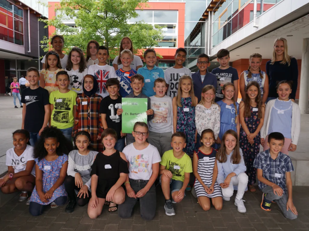 Klassenfoto einer neuen fünften Klasse vor dem Gebäude.