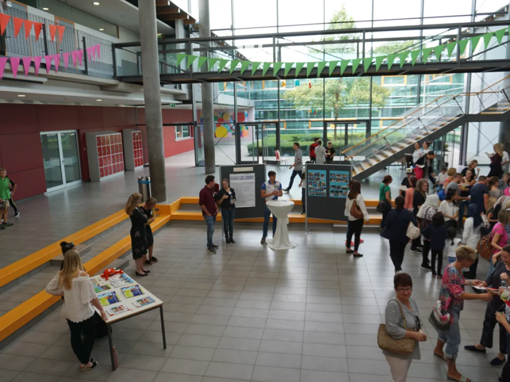 Blick ins Foyer, Familien stehen an Infotischen.