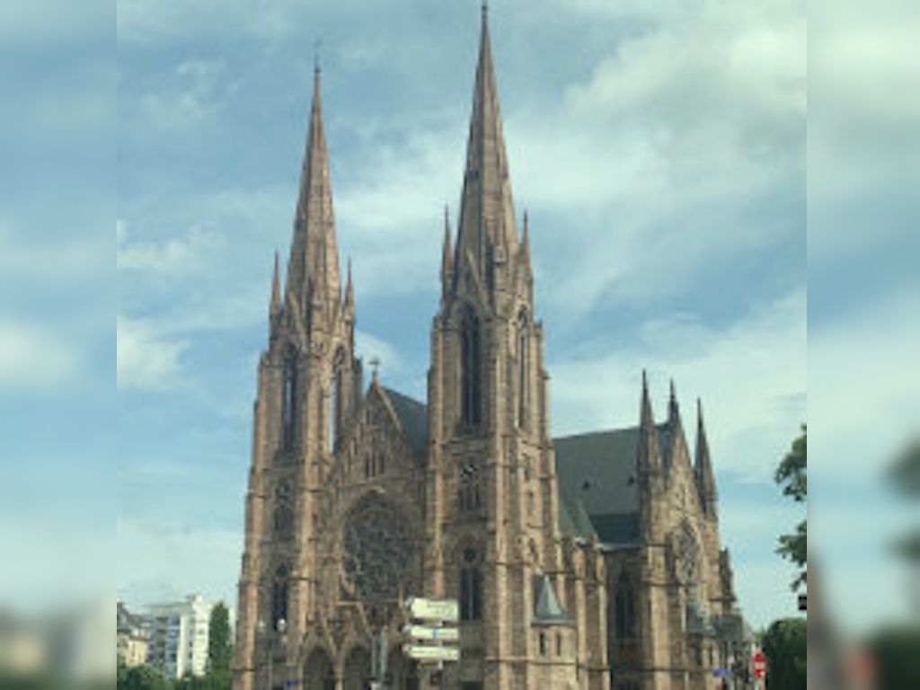 Eine große neugotische Kirche mit zwei hohen Spitztürmen und einer Rosette über dem Portal – die Paulskirche in Straßburg.