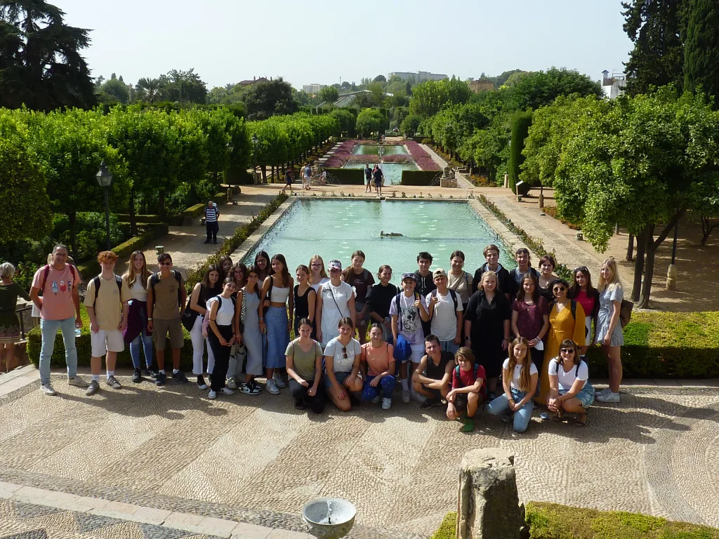 Gruppenfoto im Garten des Alcázar mit langem Wasserbecken und geschnittenen Hecken.