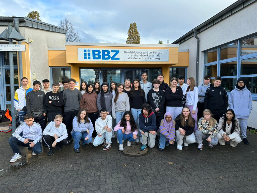 Eine große Schülergruppe posiert vor dem Gebäude des „BBZ – Berufsbildungszentrum Korbach“.