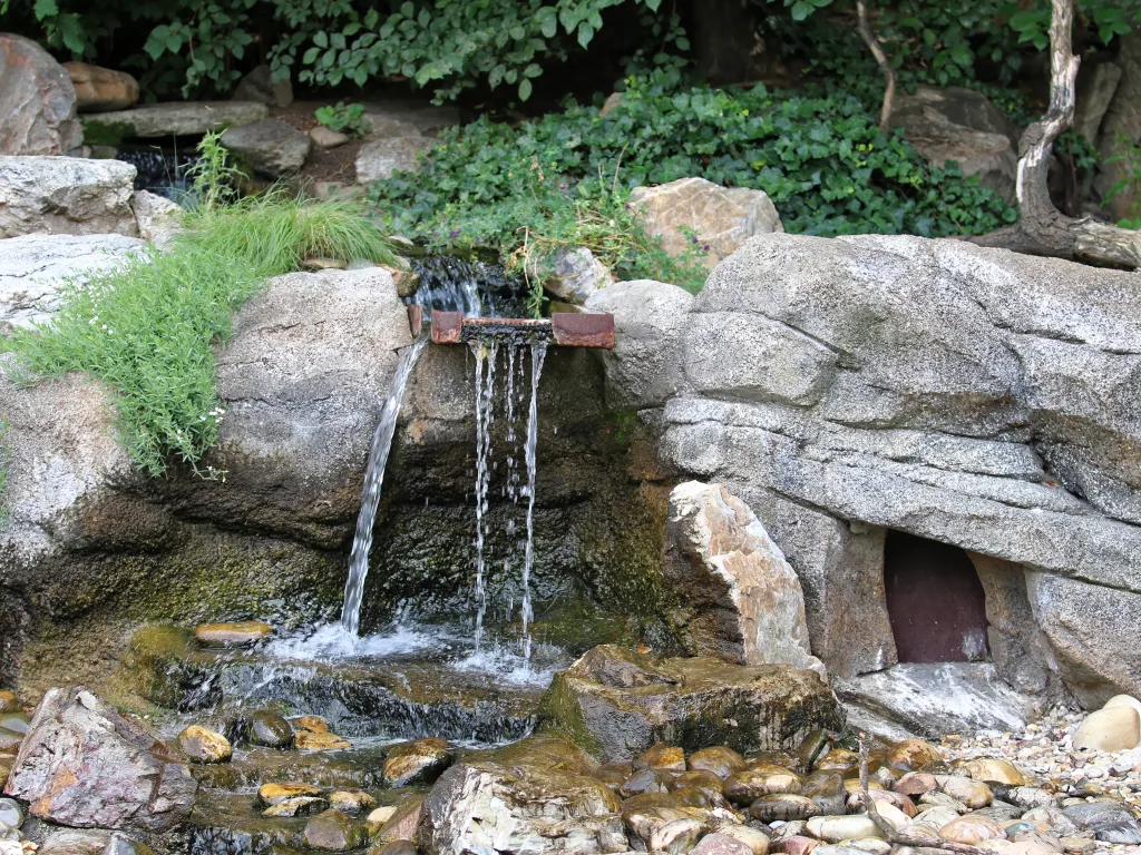 Kleiner Wasserfall über Felsstufen im Gehege.