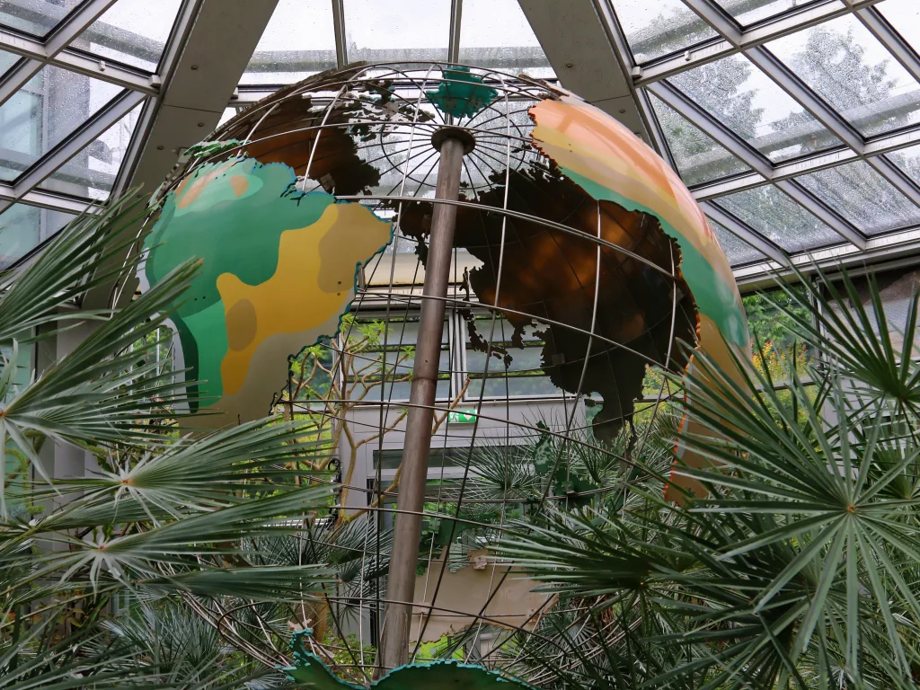 Bemalter Globus unter dem Glasdach des Gewächshauses.