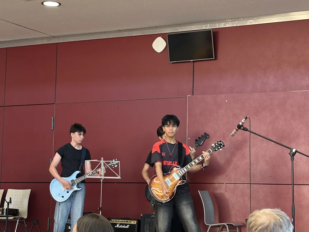 Zwei Gitarristen der Schulband spielen vor ihren Verstärkern.