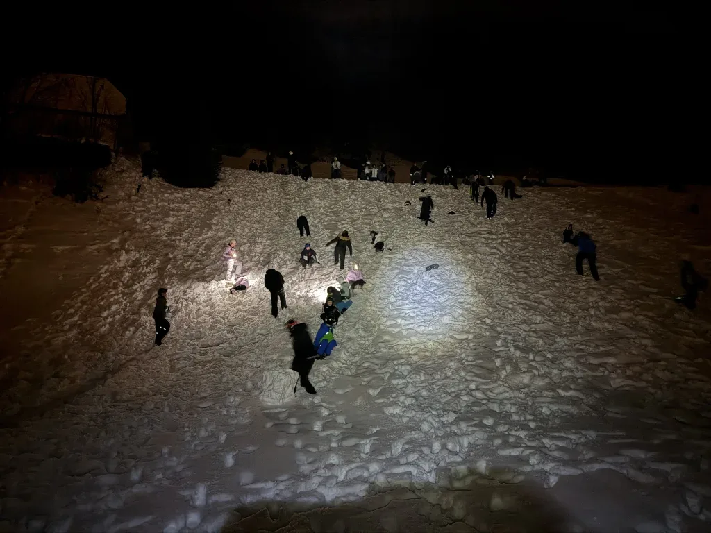 Schüler spielen während der Nachwanderung im Schnee.