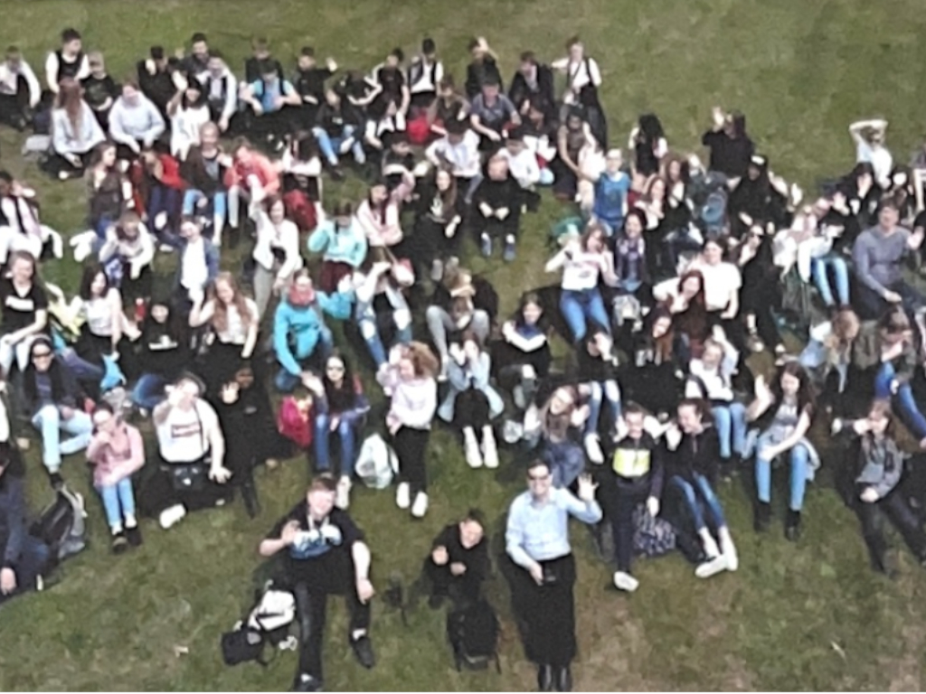 Schüler/innen mit Lehrkräften auf englischer Wiese Schüler/innen mit Lehrkräften auf englischer Wiese