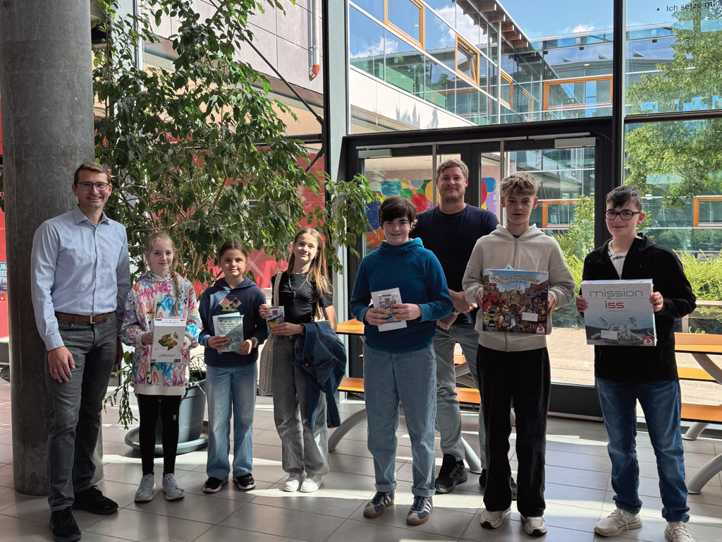 Auf dem Bild sind die Gewinnerinnen und Gewinner des Känguruwettbewerbs, sowie Michael Becker (Schulleiter) und Fabian Meyer (Mathematikkoordinator der 5. und 6. Klassen) zu sehen