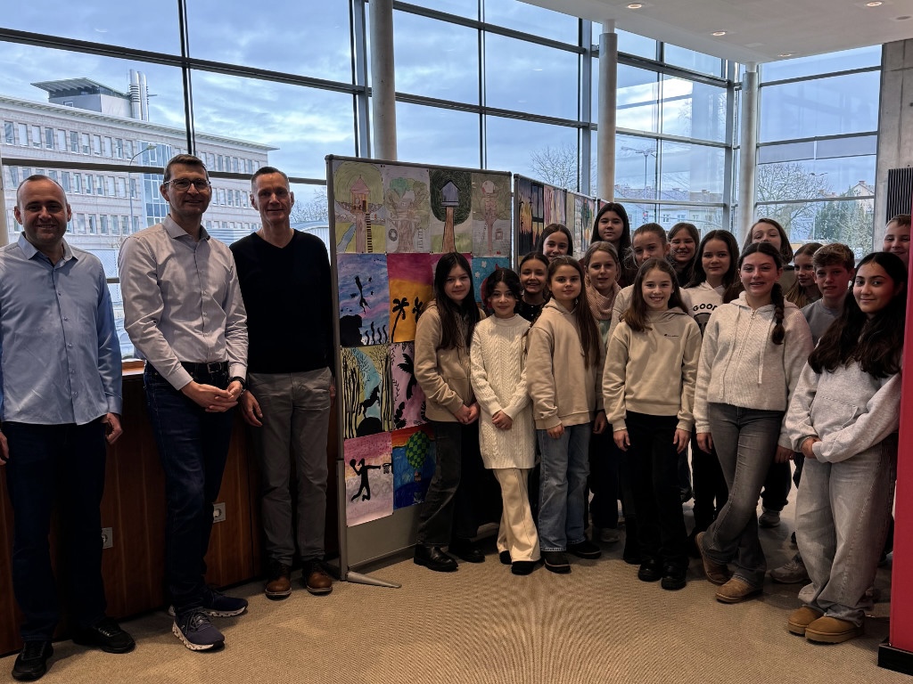 Schülergruppe mit Lehrkräften und Bibliotheksmitarbeiter vor der Kunstausstellung